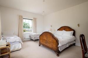 a bedroom with two beds and a window at Finest Retreats - Walltree House in Brackley