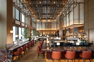 a restaurant with orange chairs and a bar at Conrad Nagoya in Nagoya
