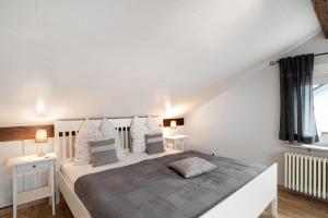 a bedroom with a large white bed with two night stands at Schwarzwaldtani - Dörfle in Weier