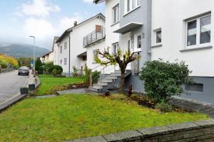 a house with a tree in the grass next to a street at Schwarzwaldtani - Dörfle in Weier