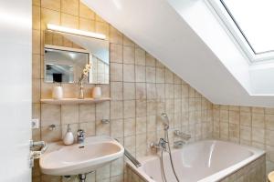 a bathroom with a sink and a bath tub at Schwarzwaldtani - Dörfle in Weier +11 photos