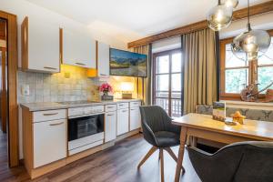 a kitchen with white cabinets and a wooden table at Appartements Lehenhof in Sankt Johann im Pongau +72 photos