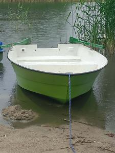 a green and white boat sitting in the water at Wakacyjne relaksacyjnie in Szczytno +2 photos