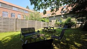 a yard with benches and a table and a fence at Domaine Les Tourelles - Gîte 4 in Caffiers