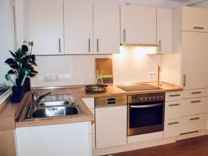 a kitchen with white cabinets and a sink at Ferienwohnung deine Rauszeit in Seebach