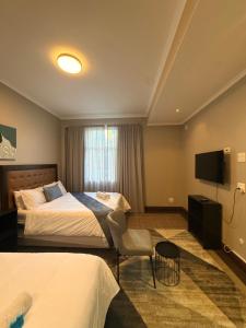 ein Hotelzimmer mit zwei Betten und einem Fernseher in der Unterkunft CapePod City Centre in Kapstadt
