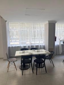 ein Tisch und Stühle in einem Zimmer mit Fenstern in der Unterkunft CapePod City Centre in Kapstadt