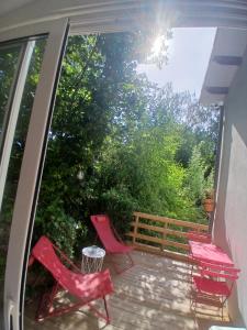 a balcony with red chairs and a fence at Le nid douillet in Aydat