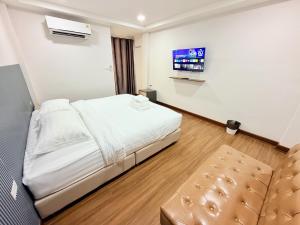 a hotel room with a bed and a tv at ยูพี โคซี่ in Nakhon Nayok