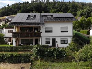 a white house with a balcony on top of it at Ferienwohnung am Südhang in Gernsbach