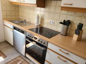 a kitchen with a stove and a sink at Ferienwohnung am Südhang in Gernsbach +12 photos