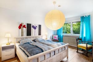 a bedroom with a large bed and a chandelier at fewo-loh4-sinsheim in Sinsheim
