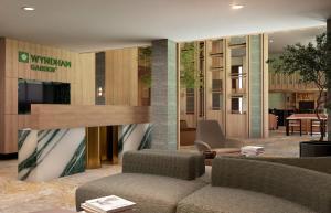 a lobby with a couch and chairs in a building at Wyndham Garden Sartell/St. Cloud in Sartell