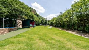 a large grassy yard with a building and trees at Gapyeong Santa Maria Dog-friendly Privat in Gapyeong