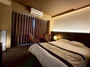 a hotel room with a bed and a window with a table at ITOSHI Kyoto Stay 京都天神401 in Kyoto