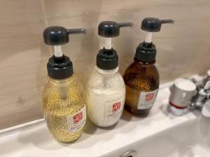 three bottles of essential oils sitting on a sink at ITOSHI Kyoto Stay 京都天神401 in Kyoto