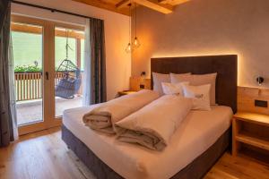 a bedroom with a bed with white sheets and a window at Lüch dl Chessl - Kesslhof in San Martino in Badia