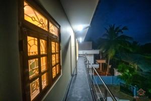 a balcony of a building at night with a palm tree at Zen Nallur in Jaffna +4 photos