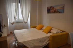 a bedroom with a bed with two yellow pillows on it at Sunny Apartment in La Spezia
