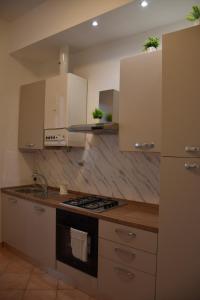 a kitchen with white cabinets and a stove top oven at Sunny Apartment in La Spezia