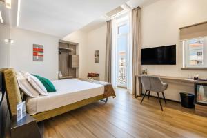 a hotel room with a bed and a desk at Municipio Luxury Suite in Naples