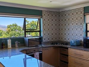 a kitchen with a counter and a window with a view at Pearl Vista in Somerset West
