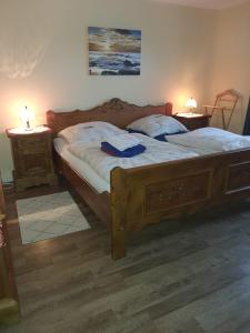 a bedroom with a large wooden bed with two night stands at Ferienwohnung Schneifelsicht in Auw