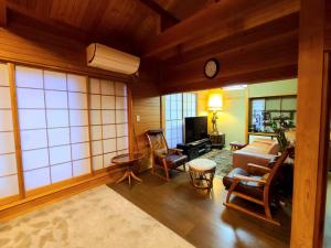 a living room filled with furniture and a clock at MAPLE HOUSE - Vacation STAY 13294v in Tsuru 