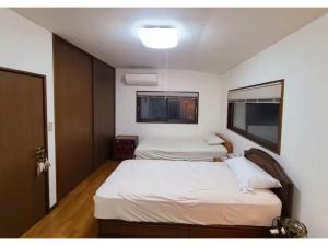 two beds in a room with two windows at MAPLE HOUSE - Vacation STAY 13294v in Tsuru  +48 photos