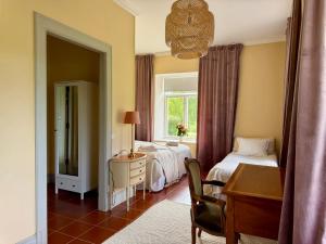 a bedroom with a bed and a desk and a window at Udden Retreat-Bed & Breakfast in Skinnskatteberg