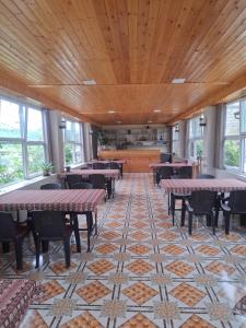 a dining room with tables and chairs on a tiled floor at Fraish air boutige in Qusar