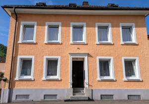 a orange building with white windows and a door at Ferienwohnung Hasenhorn in Todtnau