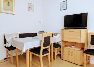 a dining room with a table and a tv at Ferienwohnung Hasenhorn in Todtnau