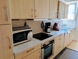 a kitchen with wooden cabinets and a microwave oven at Ferienwohnung Hasenhorn in Todtnau