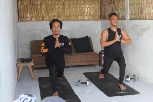 two men are doing yoga in a room at Winners surfing bali resort in Airsatang