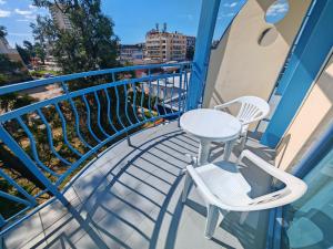 a balcony with two chairs and a table at Paloma - in the center of the city in Sunny Beach
