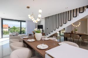 a dining room and living room with a table and chairs at Villa Perla Vir in Vir