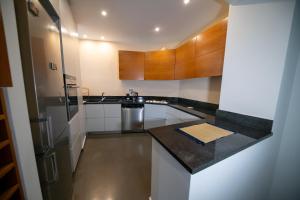 a kitchen with white cabinets and a black counter top at Acropolis Neoclassic Elegance in Athens