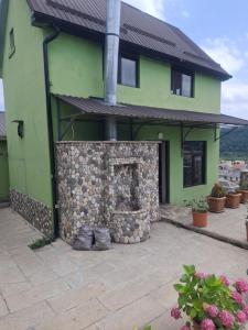 a green house with a stone fireplace in front of it at Fraish air boutige in Qusar