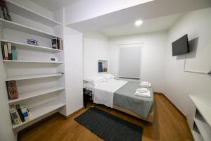 a small bedroom with a bed and shelves at Acropolis Neoclassic Elegance in Athens