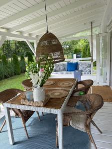 a table with chairs and a vase of flowers on a porch at Domek holenderski Hampton in Dominice