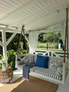a porch with a couch under a pergola at Domek holenderski Hampton in Dominice +18 photos