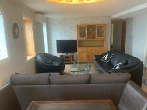 a living room with a couch and two chairs at Ørntua in Rekdal