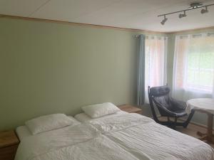 a bedroom with a bed and a table and a window at Ørntua in Rekdal
