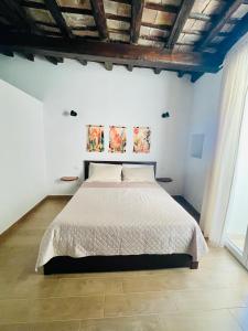 a bedroom with a bed in a white room at Loft Al Baglio del Gelso in Balestrate