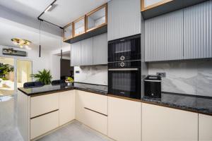 a kitchen with white cabinets and black appliances at Villa Christy in Čara