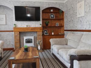 a living room with a couch and a fireplace at 31 Ffordd Y Maer in Pwllheli