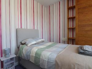a bedroom with a bed and a book shelf at 31 Ffordd Y Maer in Pwllheli