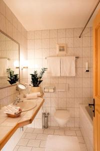 a bathroom with a sink and a toilet and a tub at Bergidyll & Hotel Trofana in Leutasch +68 photos