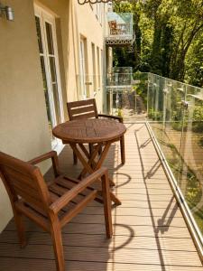 a wooden table and two chairs on a balcony at Watersmeet Terrace in Lynmouth